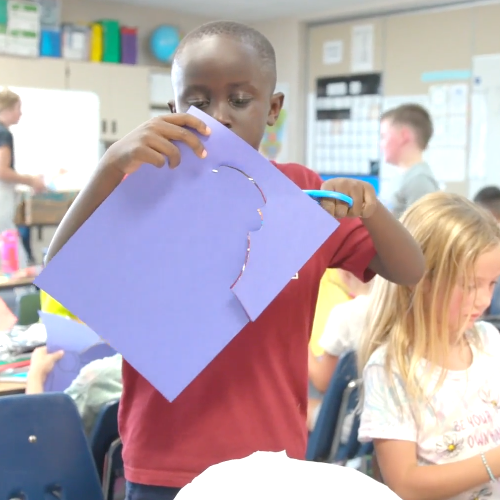  Student cutting paper.